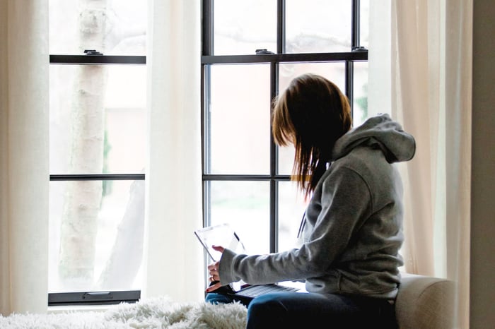 woman working from home on a laptop near a window