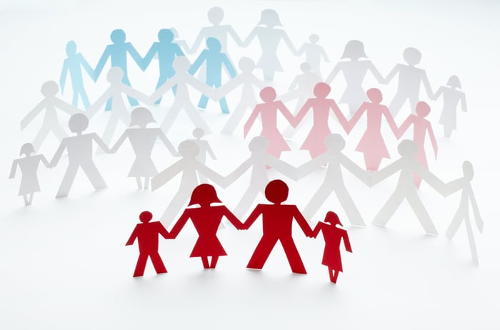 Chain of paper people holding hands on white background